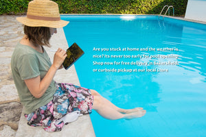 Woman reading poolside with feet in water